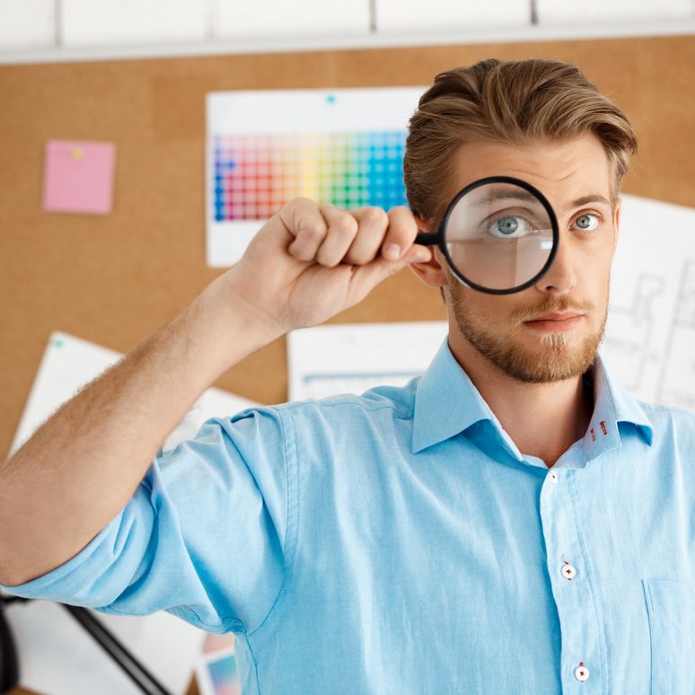 A magnifying glass resting on a laptop keyboard